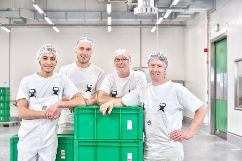 Čtyři kolegové z výroby Hügli v Zásmukách u přepravky s produkty